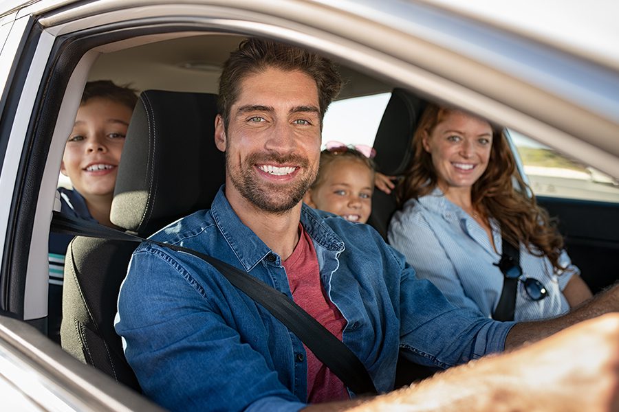 Personal Insurance - Happy Family Posing and Smiling in their Car Before Leaving to go on a Vacation